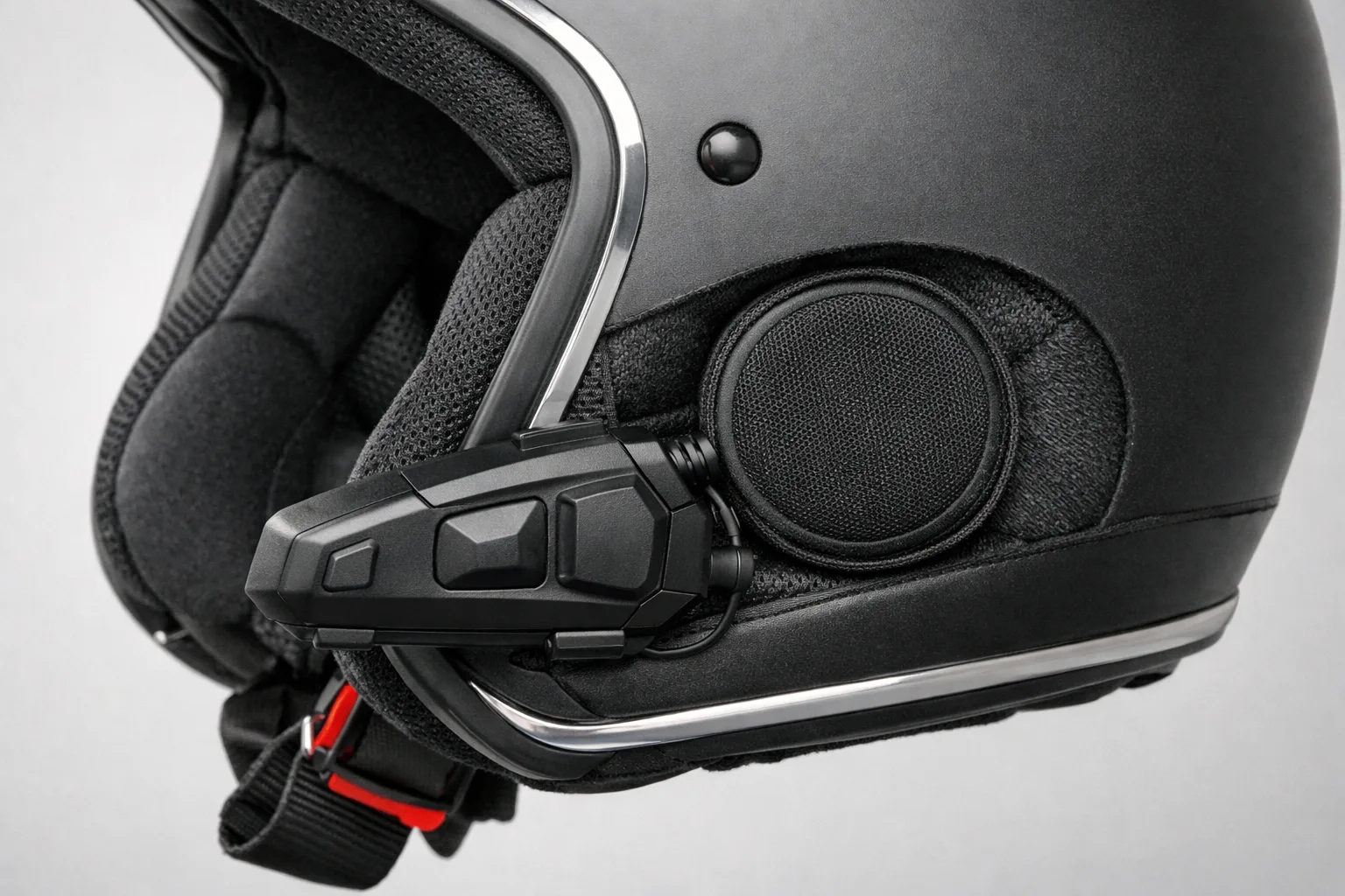 Boîtier d’intercom fixé à la coque d’un casque et haut-parleur installé dans son rembourrage.